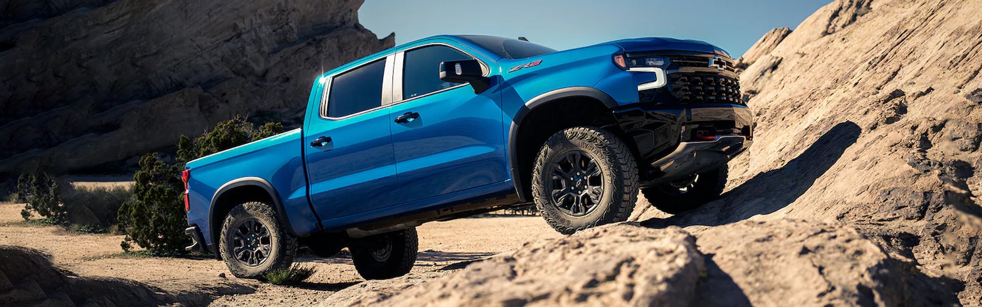 Blue Chevrolet Silverado 1500 offroading on mountain